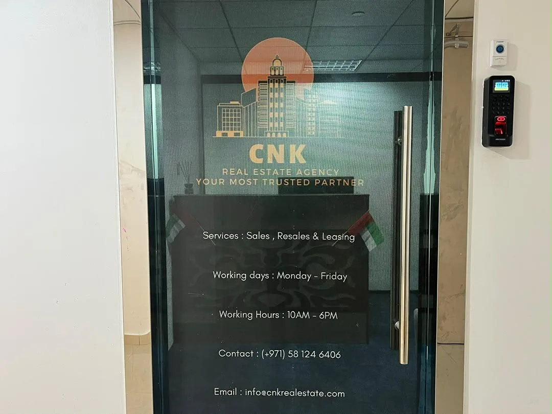 The glass entrance to CNK Real Estate with the company logo and contact information